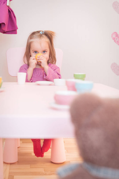 2 anos de idade menina jogando chá festa com um ursinho de pelúcia
 - Foto, Imagem