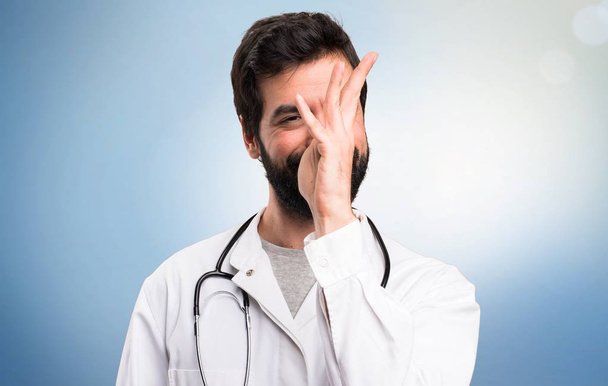 Giovane medico fare uno scherzo su sfondo blu
 - Foto, immagini