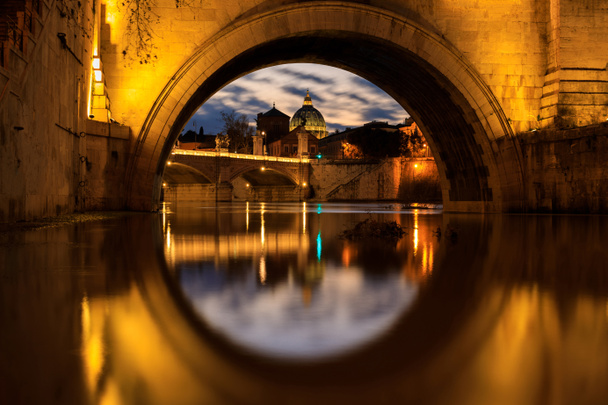 De koepel van de Sint Pieterskerk in Vaticaan, bekijken via de boog van de brug, 's avonds tijd - Foto, afbeelding