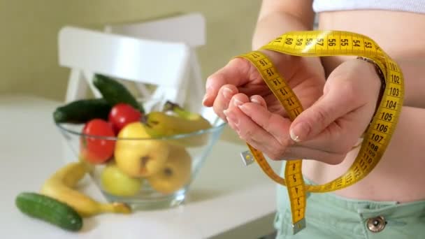 schlanke Frau halten Maß auf dem Hintergrund eines Tellers mit Obst und Gemüse, einen gesunden Lebensstil - Filmmaterial, Video