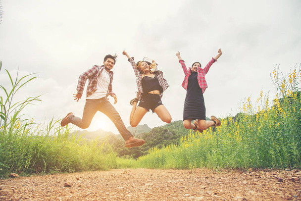Group of Teenagers Jumping at yellow flower field,enjoying with  - Foto, imagen