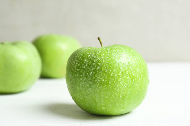 Fresh green apple with water drops on white table - Fotografie, Obrázek