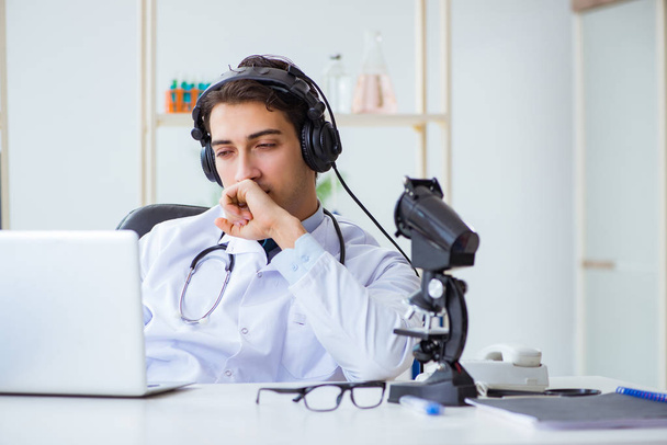 Mužský lékař naslouchá pacientovi během telemedicínského sezení - Fotografie, Obrázek