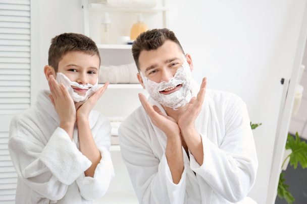 Dad teaching his son to shave in bathroom - Фото, изображение