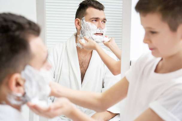 Dad teaching his son to shave in bathroom - Фото, зображення