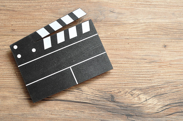 Un tablero de cine en blanco y negro sobre un fondo de madera
 - Foto, Imagen