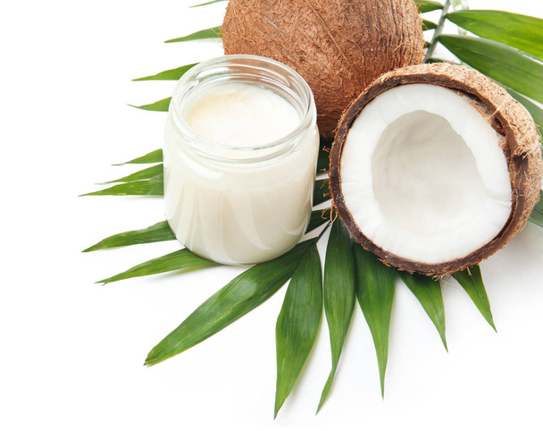 Jar with coconut oil and nuts on white background - Zdjęcie, obraz