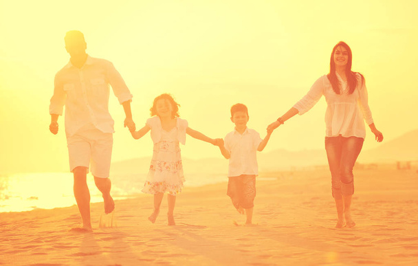 šťastná mladá rodina bavit na pláži při západu slunce - Fotografie, Obrázek