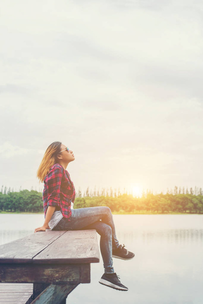 Νεαρά πανέμορφο hipster γυναίκα κάθεται στην προβλήτα στη λίμνη, χαλαρή  - Φωτογραφία, εικόνα