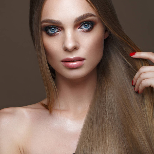 Beautiful blond girl with a perfectly smooth hair, classic make-up. Beauty face - Фото, изображение