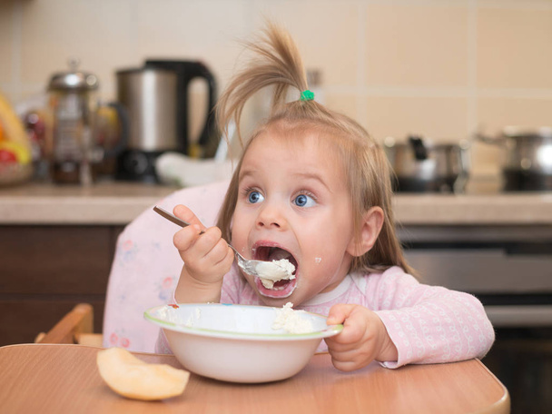 1,5 anos de idade menina comendo sozinha
 - Foto, Imagem