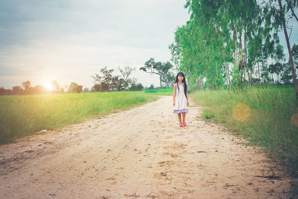 Menina com cabelo comprido vestindo vestido está andando longe de yo
 - Foto, Imagem
