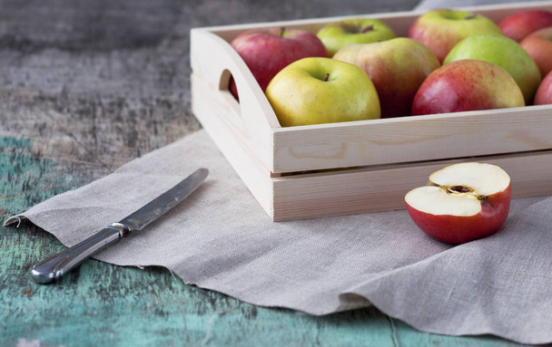 Manzanas frescas en bandeja sobre fondo de madera. Las manzanas son rojas, verdes, amarillas. Alimentación saludable Vitaminas Vegetariana Cosecha estacional
. - Foto, imagen