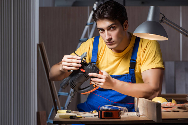 Рабочий, работающий в ремонтной мастерской по деревообработке - Фото, изображение