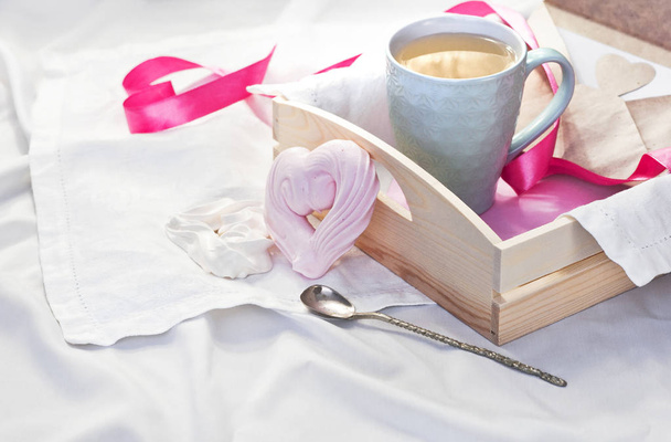 Піднос з чашкою гарячого чаю та домашнім злиттям у вигляді серця в ліжку на білому текстилі. Трав'яний чай Гарячий напій Любов Сніданок у ліжку Ранок
 - Фото, зображення