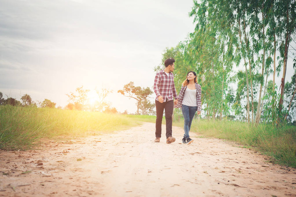 Fiatal csípő pár vidéki úton élvezi a természet járás, - Fotó, kép