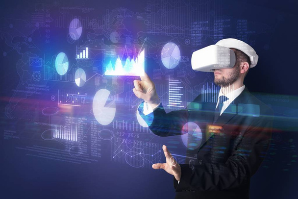 Man wearing VR goggles with charts and reports - Φωτογραφία, εικόνα