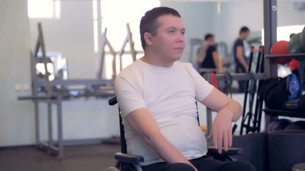Postižený člověk je natahovat ruce a ramena při sezení na vozíku  - Záběry, video