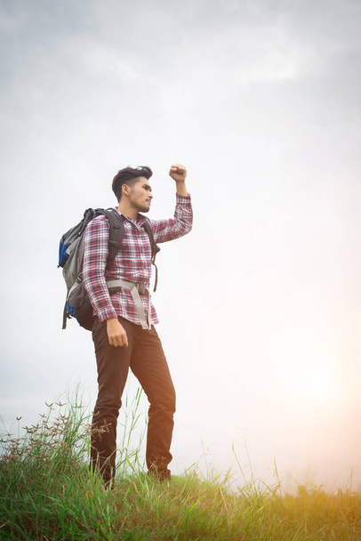 Portrait of young hipster man outdoor raising hands with backpac - Foto, afbeelding