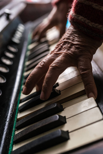 Παλιά μουσικός παίζει πιάνο σε εσωτερικούς χώρους σε μια προβολή closeup του ΧΑ - Φωτογραφία, εικόνα