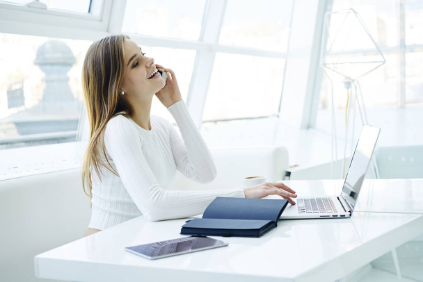 Cheerful young female freelancer confirming booking on website contact service operator.Business woman satisfied with making successful project getting congratulations through cellular conversation - Фото, зображення