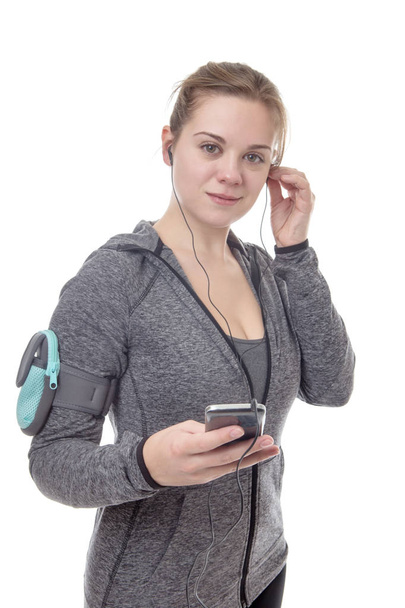 female fitness model listening to music on her mobile phone - Zdjęcie, obraz