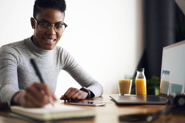 Smiling attractive afro american designer making sketch in notebook satisfied with creating solution for project, charming businesswoman with short haircut writing working schedule in personal diary  - Fotoğraf, Görsel
