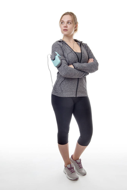 female fitness model listening to music on her mobile phone - Fotó, kép