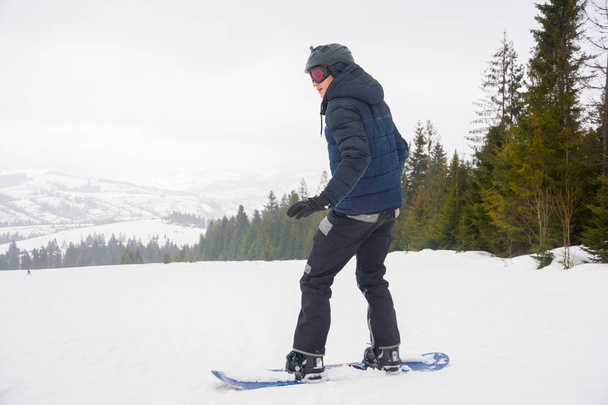 Un giovane uomo in occhiali sportivi e con il casco sta cavalcando una neve
 - Foto, immagini