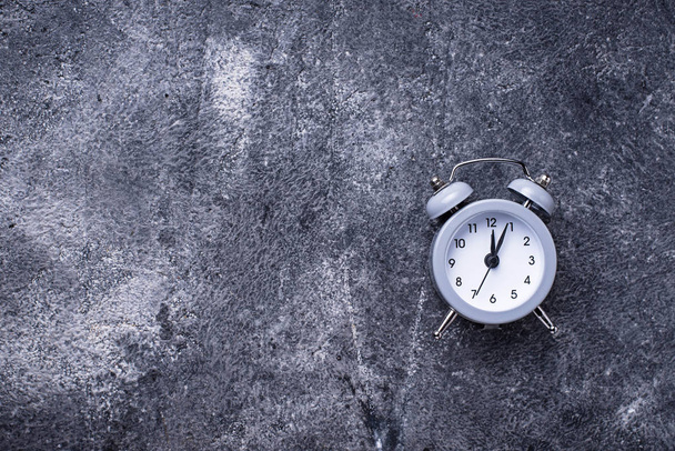 Relógio de alarme vintage cinza na mesa de concreto
 - Foto, Imagem