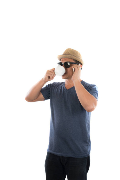 Handsome hipster young man in hat and sunglasses standing and ta - Photo, Image