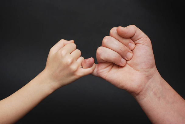 Father holding Daughter hand. Friendly parental relationships. Black Background. - Foto, imagen