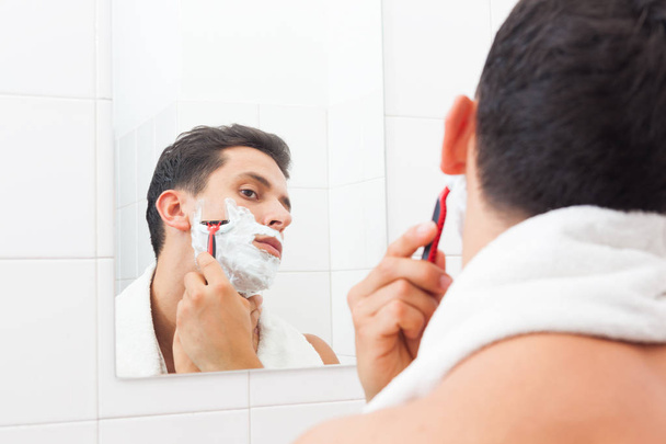 beau mec rasage sa barbe avec rasoir à la salle de bain
 - Photo, image