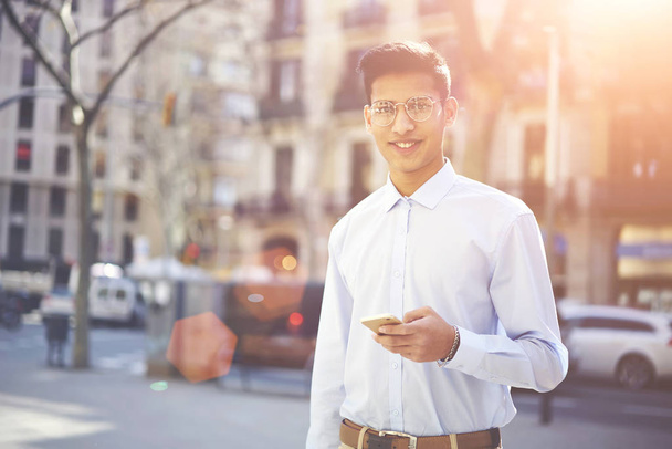 Kırpılmış görüntü optik gözlük cep telefonunda mesaj okuma ciddi hindu öğrencinin. Düşünceli erkek gözlük meslektaşım hızlı 4 g internet bağlantısı üzerinden sms gönderme kahve ' - Fotoğraf, Görsel