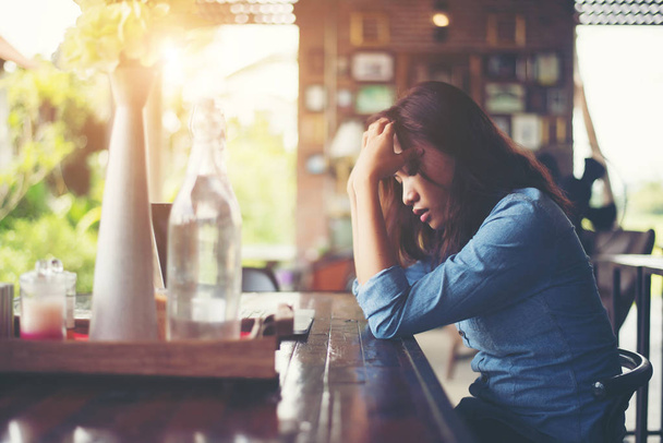 Молодая женщина сидит в кафе со своим ноутбуком, стресс для вор
 - Фото, изображение