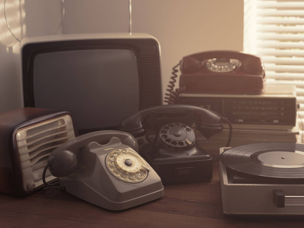 Vintage retro revival objects and second-hand appliances collection on a table: record player, television, radio and rotary dial telephones - Foto, immagini