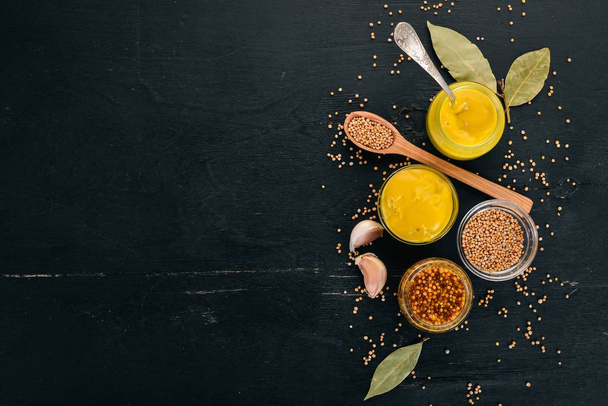 Assortment of mustard in sauces. Spices On a black wooden background. Top view. Copy space for your text. - Photo, Image