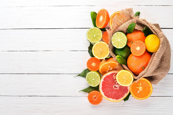 A set of citrus fruit. Orange, tangerine, grapefruit, lemon. On a wooden background. Top view. Copy space. - Fotoğraf, Görsel