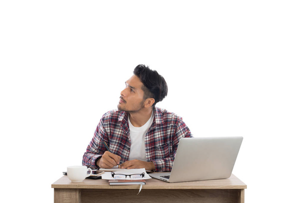Gondolkodó fiatal ember keres el, miközben ül a munkával töltött  - Fotó, kép