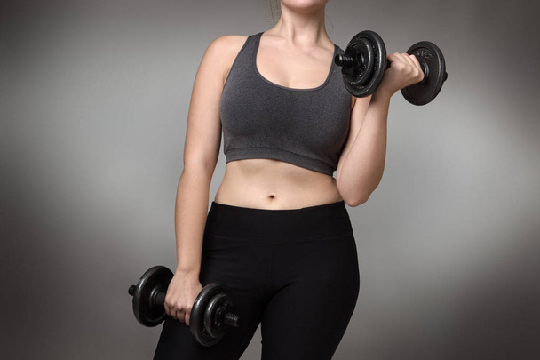close up of a woman middrifed using dumbbells - Photo, Image