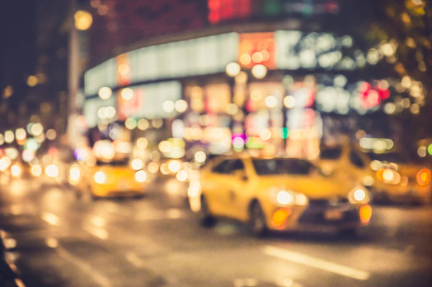 Defocus blur of New York City street scene at night with lights, cars,  yellow taxi cabs and buildings - 写真・画像