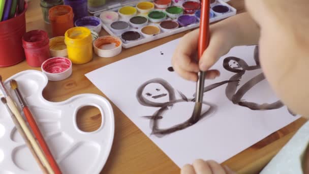 Young sad girl draws people with black paints - Materiał filmowy, wideo