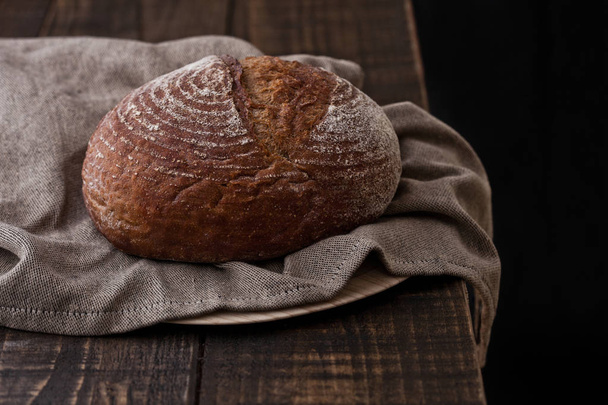 Freshly baked  bread with  kitchen towel on wood - Foto, Imagen