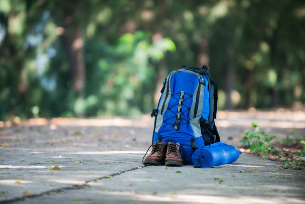 Plecak i buty backpackers odpoczynku na drodze podczas pieszą. - Zdjęcie, obraz