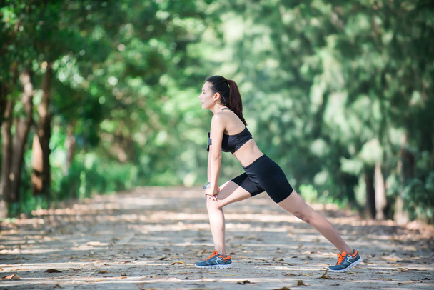 Giovane donna di fitness che allunga le gambe prima di correre
. - Foto, immagini