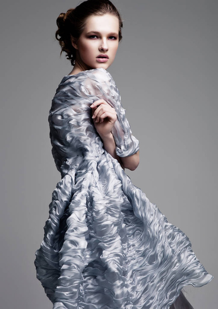 Beautiful fashion model wearing blue silk dress  - 写真・画像