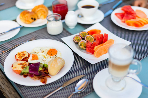 Finom reggeli tükörtojással, szalonnával, zöldségekkel és gyümölcsökkel - Fotó, kép