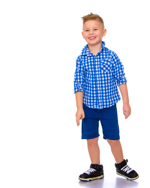 A cute little boy in a shirt and shorts. - Fotó, kép
