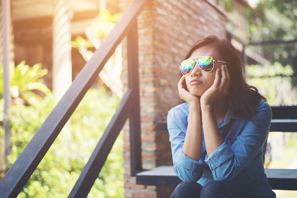 Jonge hipster vrouw zittend op trap terwijl weg wordt gekeken naar o - Foto, afbeelding
