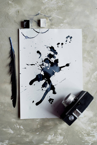 A palette of black and white paint. a sheet of white art paper with black dye ink.Old retro camera - Zdjęcie, obraz